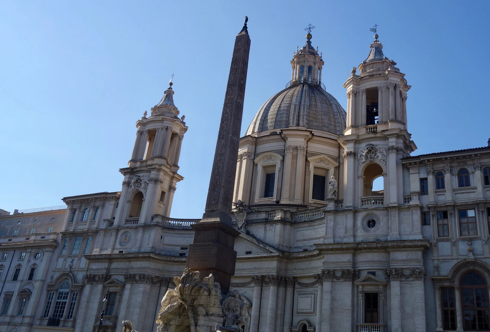 Sant&rsquo;Agnese in Agone e o obelisco vistos de perto. Este enquadramento ajuda a perceber a tensão barroca entre a igreja d