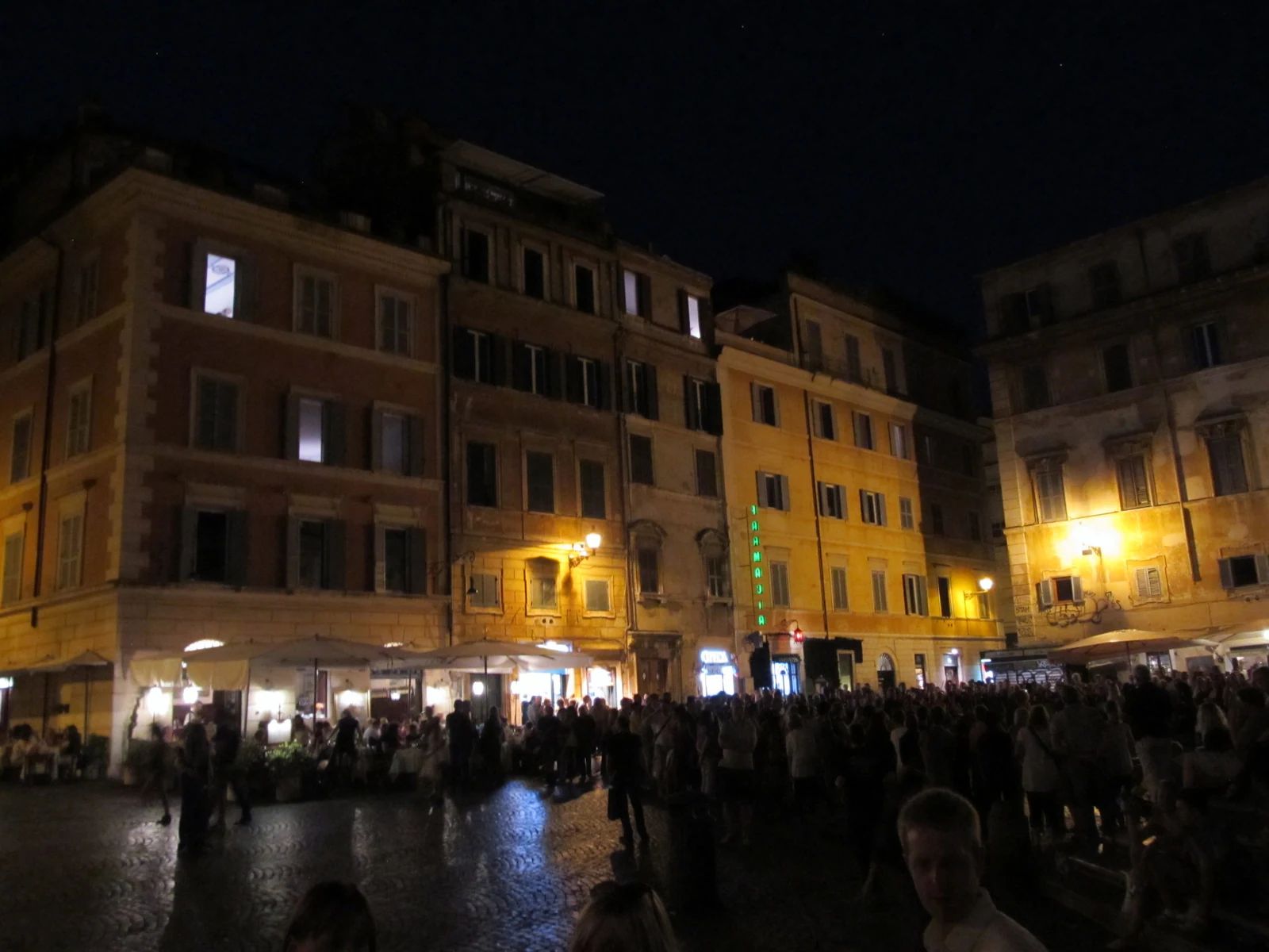 A praça depois de escurecer, já tomada por gente. É justamente essa mudança de ritmo que torna Trastevere uma boa escolh