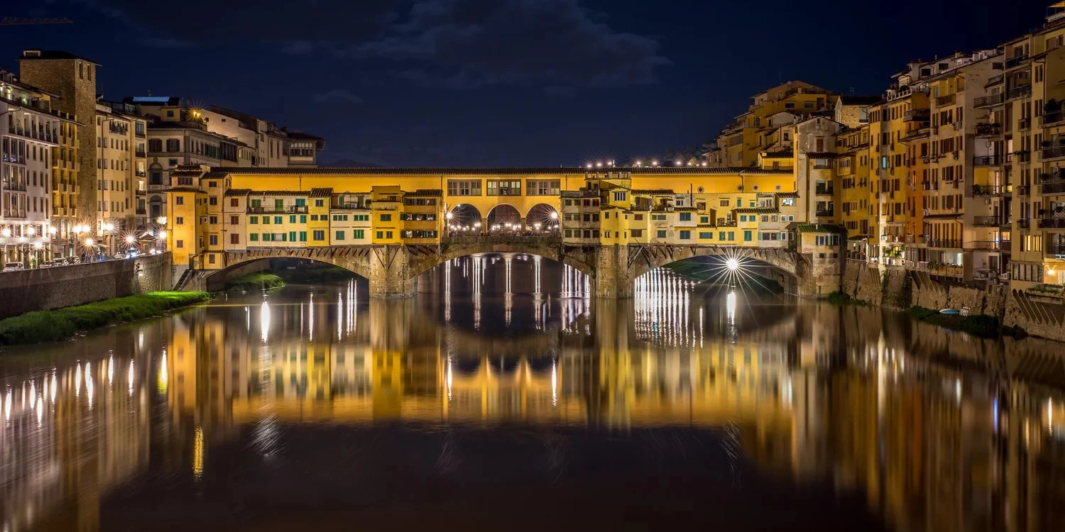Ponte Vecchio já à noite, com as luzes refletidas no Arno. Vale lembrar esta imagem porque vocês estarão hospedados no c