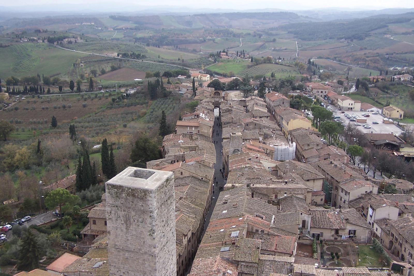 Vista a partir da Torre Grossa sobre os telhados e a paisagem da Toscana. É o contraponto perfeito ao skyline visto de f