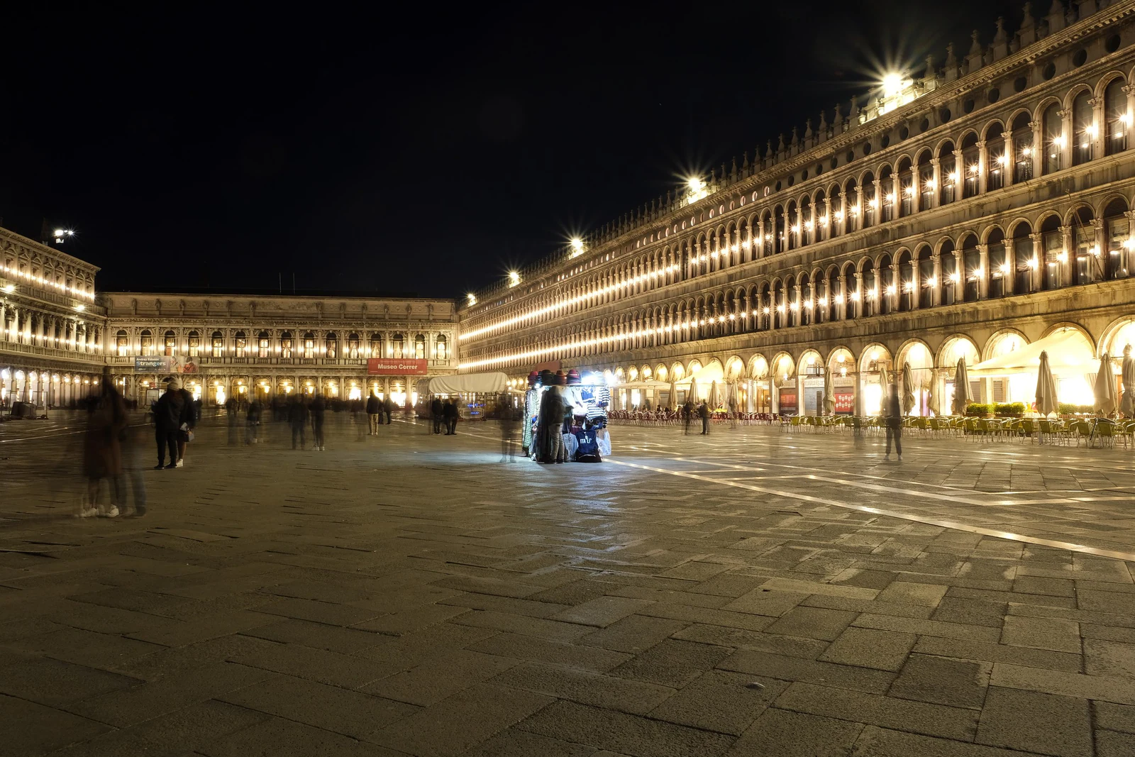 Piazza San Marco já à noite, com as Procuratie iluminadas e a praça muito mais vazia do que durante o dia. Esta é a imag