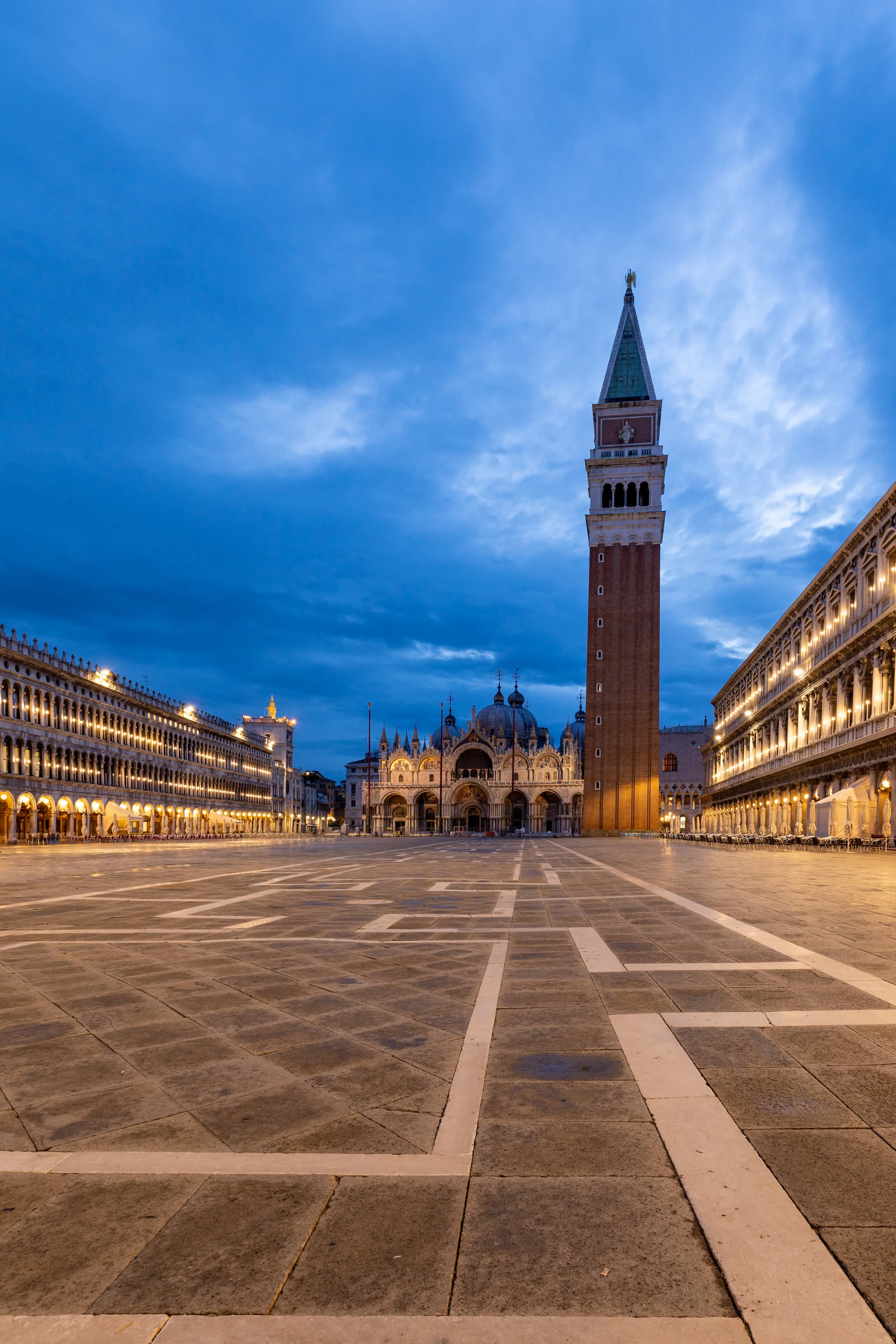 San Marco na transição entre dia e noite, quase vazia, com o Campanile dominando o centro. A blue hour é provavelmente o