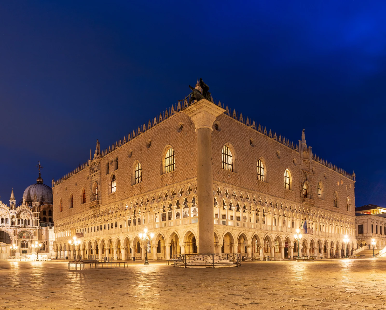 O Palazzo Ducale iluminado à noite, visto de um dos cantos da Piazzetta. A fachada parece muito mais leve do que a funçã