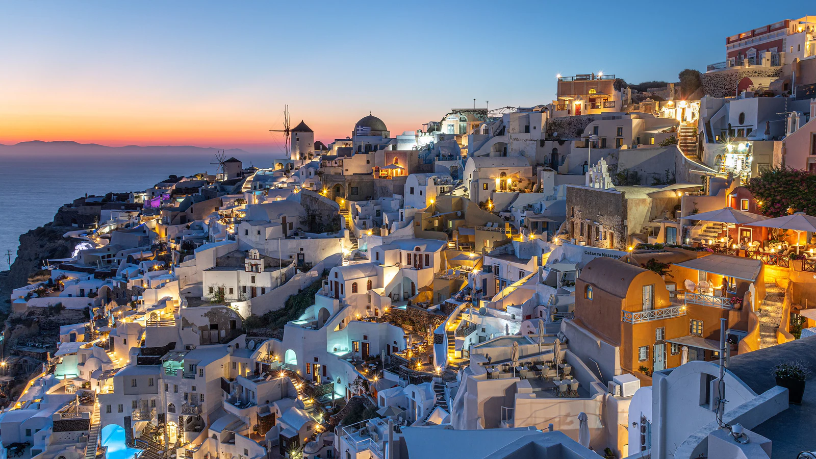 Na blue hour, as casas deixam de ser volumes brancos isolados e viram uma constelação na falésia.
