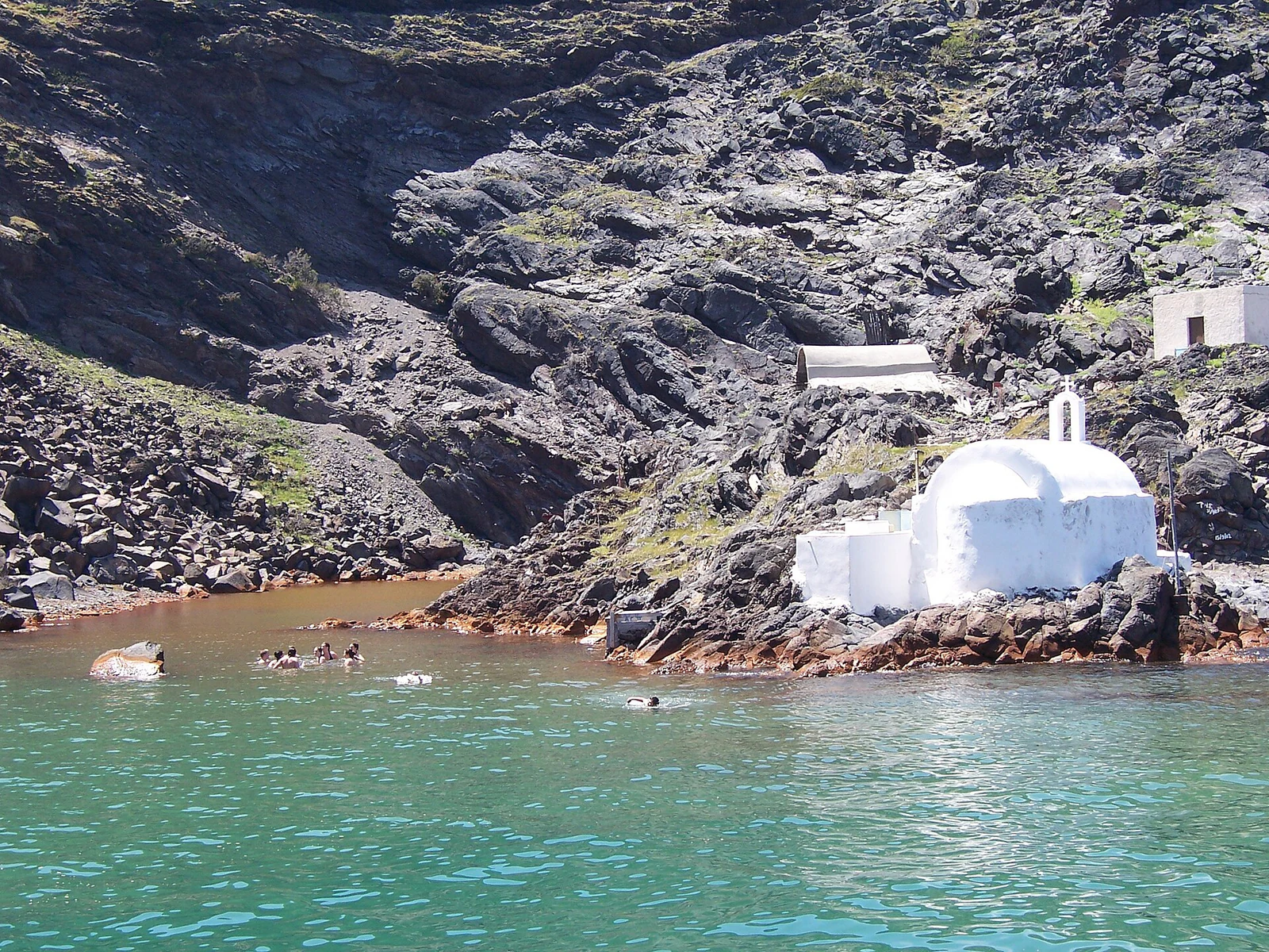 A capela branca junto às águas de Palea Kameni deixa claro que as ‘hot springs&rsquo; não são uma piscina construída.