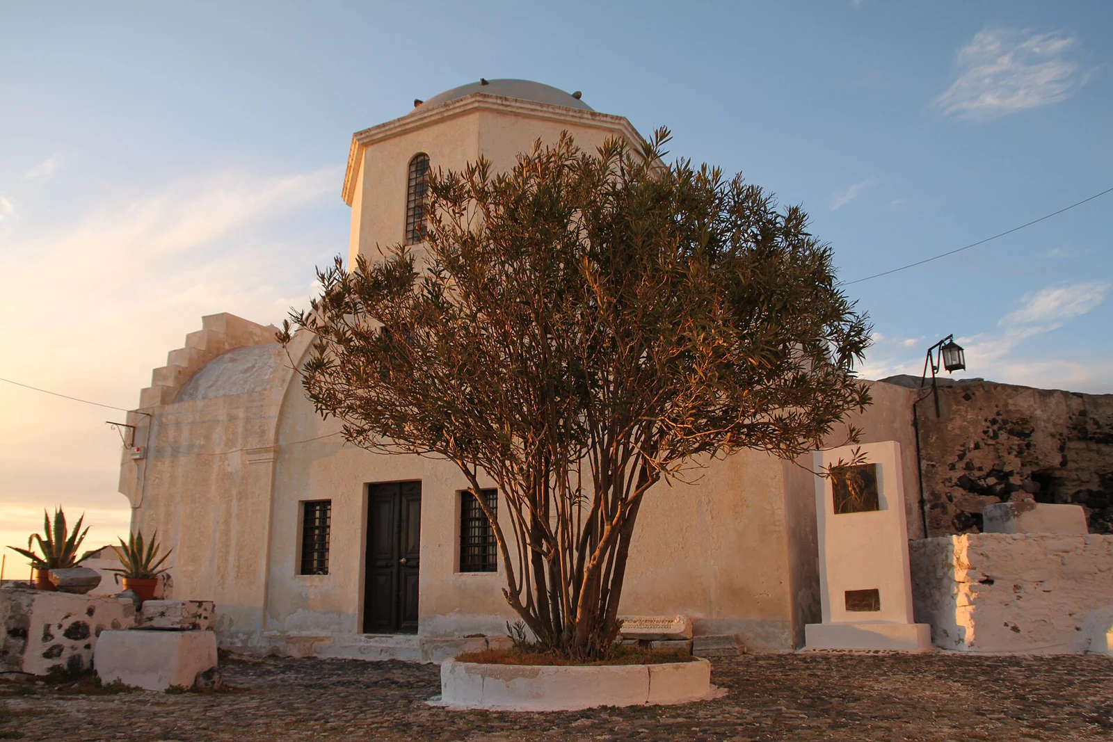 A igreja da Santíssima Trindade mostra a escala das capelas locais: volumes compactos, pátio e sombra.