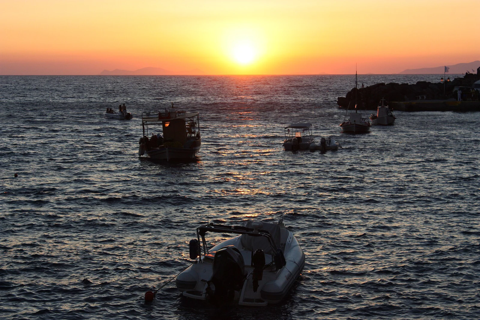 O porto ao sunset oferece uma atmosfera diferente do alto da falésia: barcos em primeiro plano, horizonte baixo e reflexos.